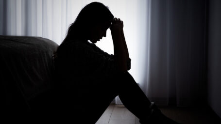 depressed woman sitting in the dark