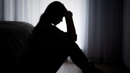 depressed woman sitting in the dark