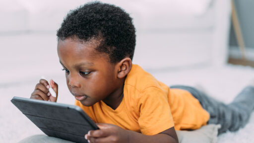 Little boy watching cartoons on digital tablet.