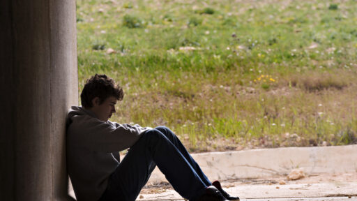 Boy sitting alone outside