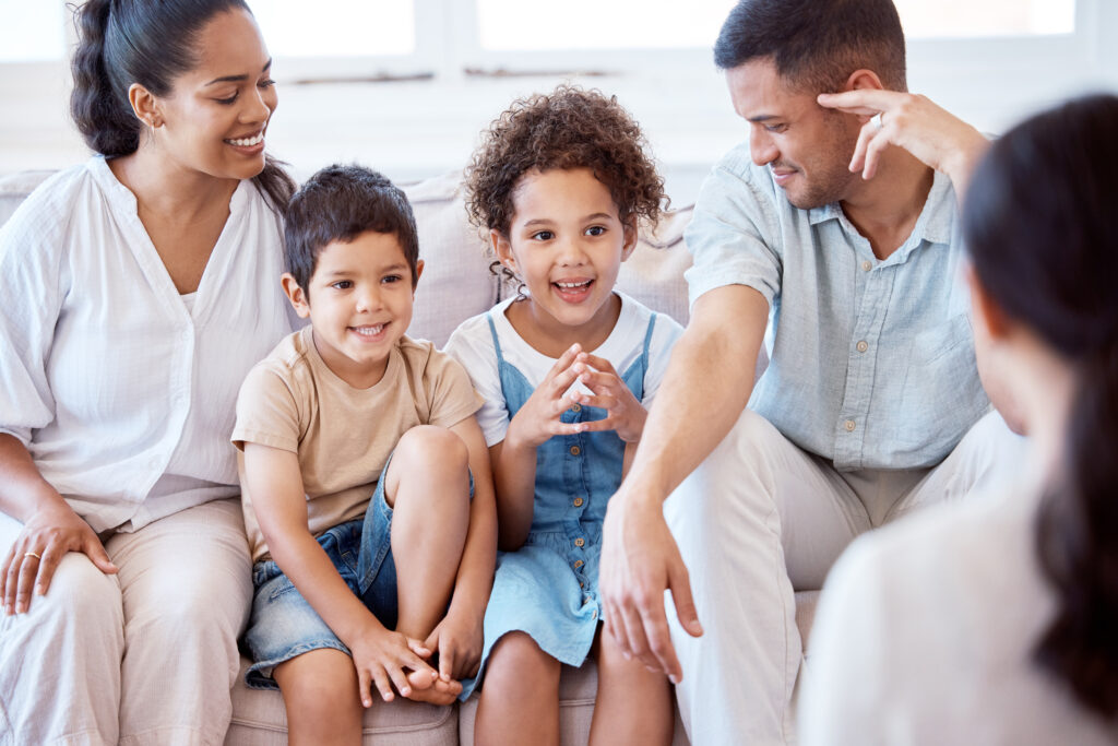 A family with two young children sitting on a couch.