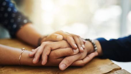 Closeup shot of two unrecognizable people holding hands in comfort