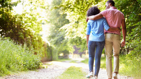 Rear View Of Young African American Couple Walking In Countryside