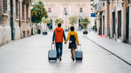 Young couple with suitcases.