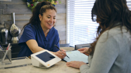 front desk worker assisting a patient