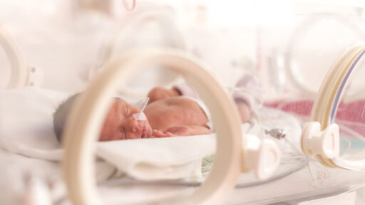 Premature newborn baby girl in the hospital incubator after c-section in 33 week