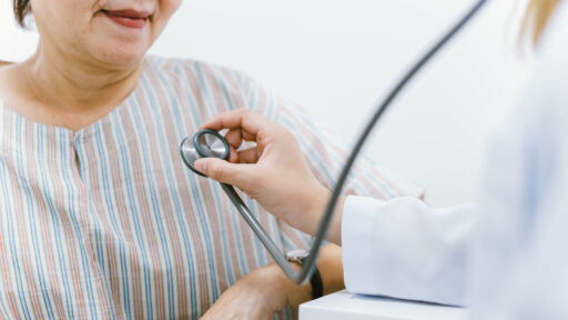 doctor using stethoscope to exam patient heart