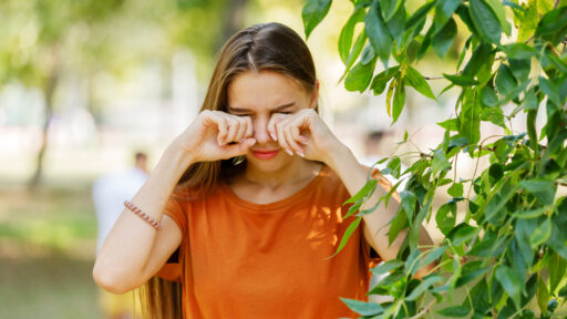 Beautiful Woman is Rubbing her Eyes in Public Park.