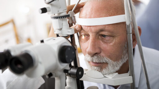 Senior man doing eye test with optometrist
