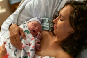 Newborn baby snuggling with mom