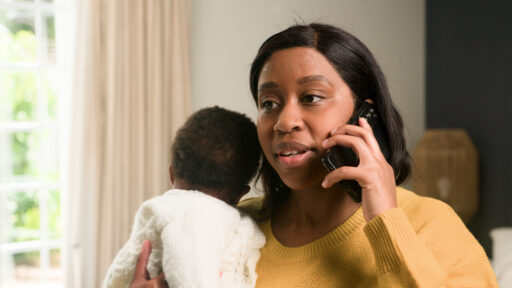 mom talking on the phone while holding a baby