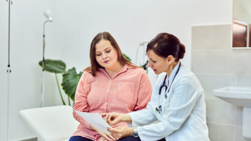 An overweight woman talking with a female doctor about her health