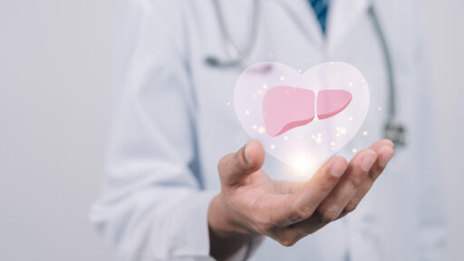doctor in uniform hands holding liver organ virtual icon, hepatitis vaccination, liver cancer treatment. Health checkup concept.