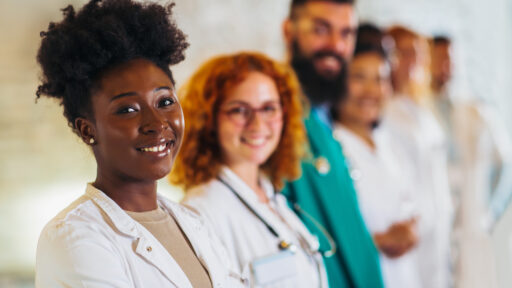 hospital, profession, people and medicine concept - group of happy doctors at hospital