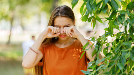 Beautiful Woman is Rubbing her Eyes in Public Park.