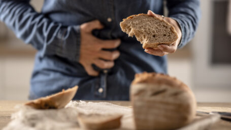 a woman experiencing gut issues after eating bread.