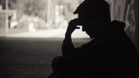 man sitting down with his head in his hands