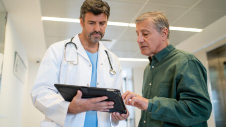 older man talking to a male doctor