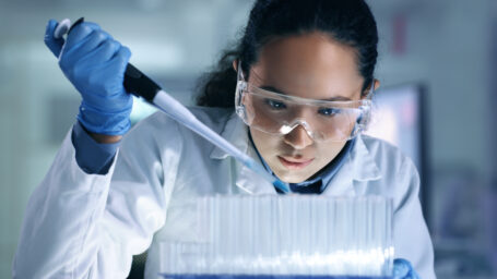 Research, experiment and trial being done by a scientist in a lab, science facility or hospital. One young, serious and professional medical researcher organizing, sorting or making a discovery