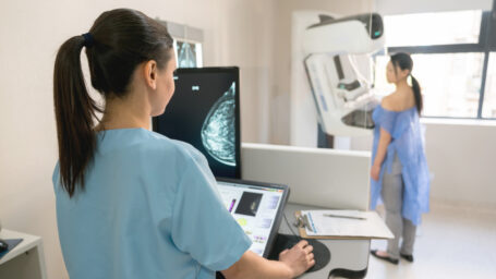 Unrecognizable nurse taking a mammogram exam to an adult patient at the hospital