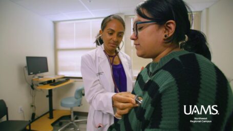 UAMS doctor uses a stethoscope to examine a patient at UAMS Northwest family medicine clinic.