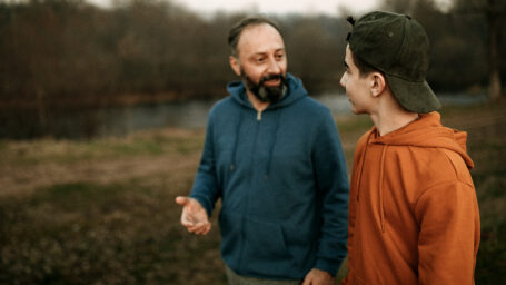 Mature man and his son walking in the public park