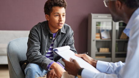 Excited teenage boy sharing his thoughts with adolescent psychologist