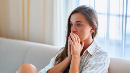 Sad upset depressed crying melancholic woman sitting alone at home