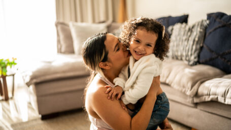 Portrait of toddler girl having fun with her mother in the living room at home