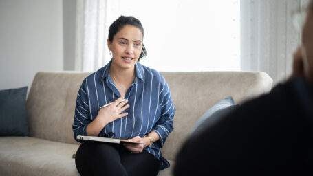 Young therapist giving advice to adult patient with female problems at home